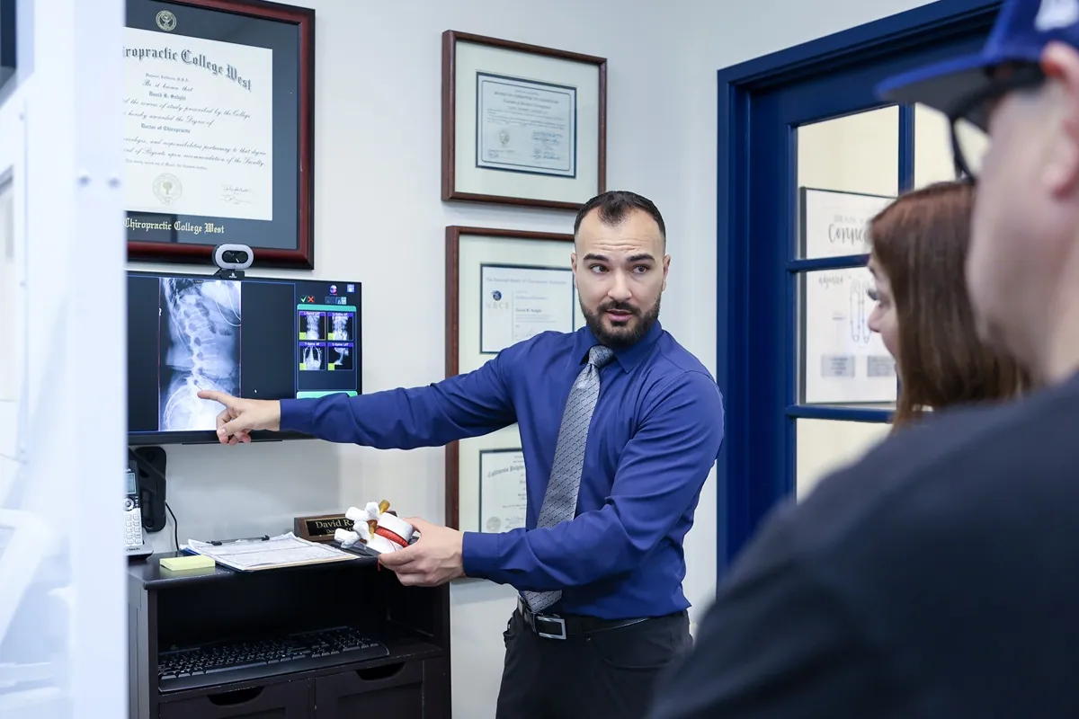 Chiropractor reviewing a spinal X-ray during a back pain consultation in San Luis Obispo, CA