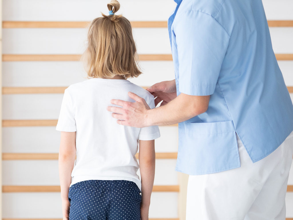 chiropractor check the back of the young girl